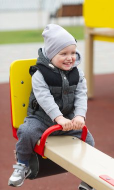 Çocuk bir salıncağa oturur.