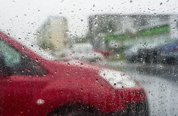 O carro vermelho através de vidro molhado . — Fotografia de Stock
