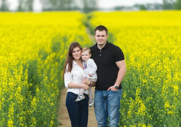 Happy family have a rest on the yellow rape field. — Stock Photo, Image