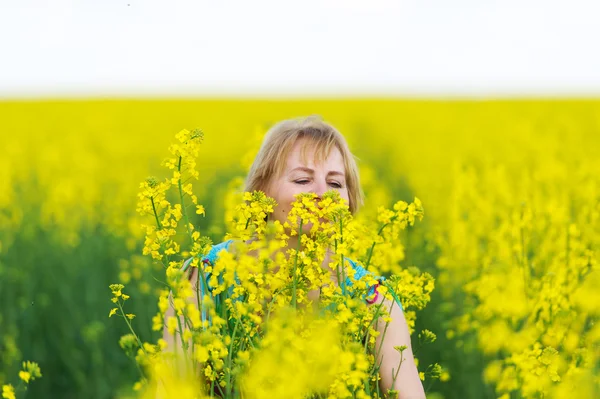 A mulher cheira a aromas de flores de primavera . — Fotografia de Stock