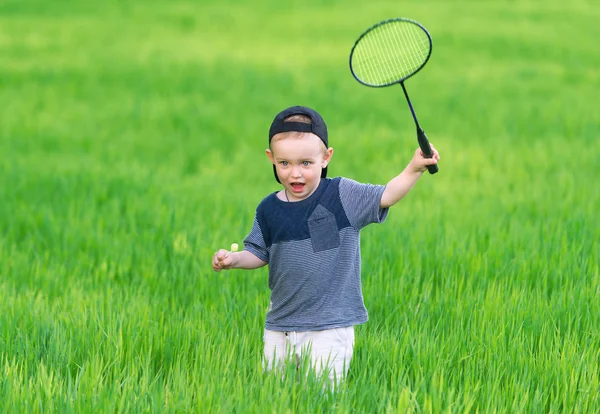 Het kleine jongetje in het GLB speelt in gras. — Stockfoto