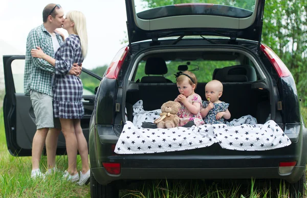Two kids sit in a car luggage carrier. — Stock Photo, Image