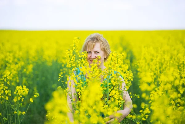 La mujer y la floreciente colza amarilla . — Foto de Stock