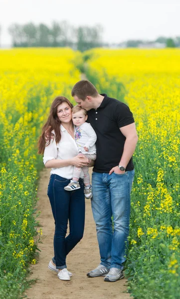 Family portrait on the blossoming rape field. — Stock Photo, Image