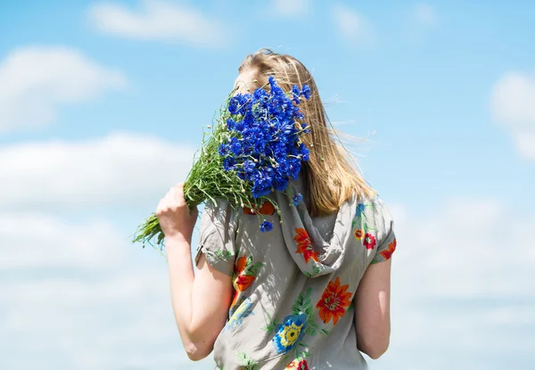 La chica con un ramo de acianos en el fondo del cielo . — Foto de Stock