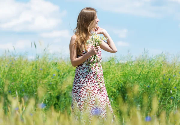 Retrato de mujer hermosa con flores en el campo — Foto de Stock