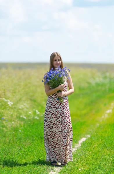 Retrato de mujer hermosa con flores en el campo —  Fotos de Stock