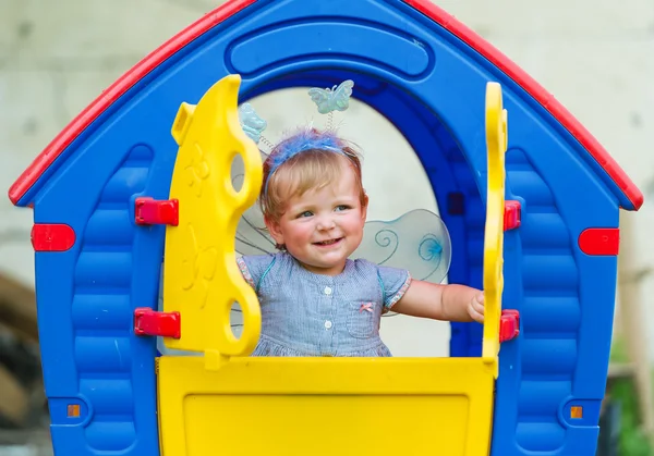 Little fairy met vleugels kijkt uit Kinder lodge. — Stockfoto