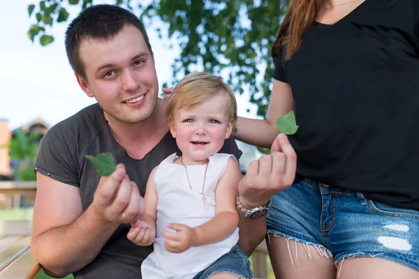 The father, mother and the little daughter have a rest  joke outdoors. — Stock Photo, Image