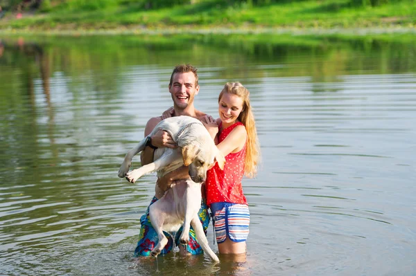 Lyckliga paret och hunden bada i sjön. — Stockfoto