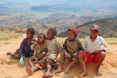 Tired children sit on sand. Madagascar. Antananarivo. clipart