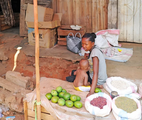 La mujer con bebé vende mango en el mercado agrícola. Antananarivo. Madagascar . — Foto de Stock