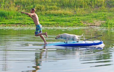 Genç adam ve köpeği tekne. Atlar içinde su.