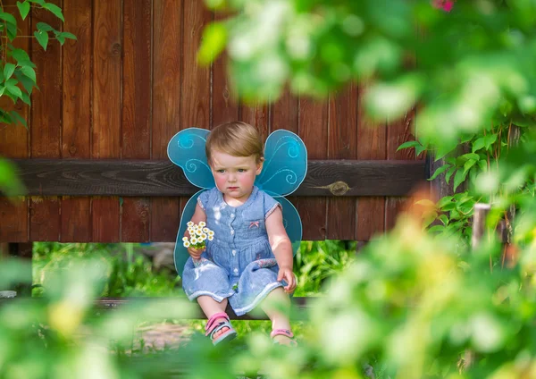 La pequeña hada triste en un vestido azul con ramo de margaritas blancas . —  Fotos de Stock