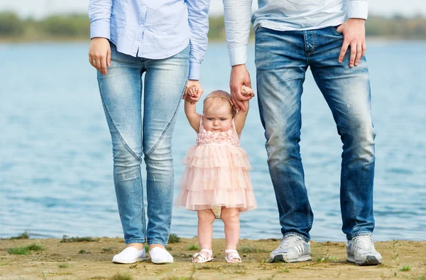 De kleine dochter kosten tussen de benen van ouders. — Stockfoto