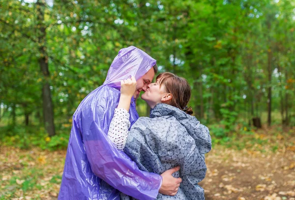 Par i regnrockar embracing på hösten skogen — Stockfoto