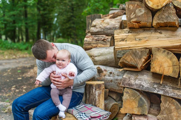 Χαρούμενος νεαρός μπαμπάς κρατώντας το μικρό κορίτσι του στο Φθινοπωρινό δάσος — Φωτογραφία Αρχείου