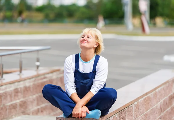 Retrato da mulher feliz no uniforme sentado em uma pose de lótus . — Fotografia de Stock