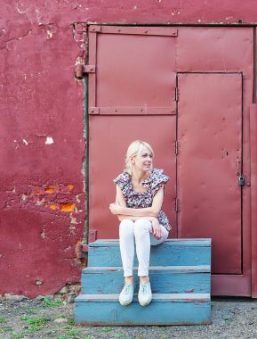 basamaklarında oturan sarışın genç kadın