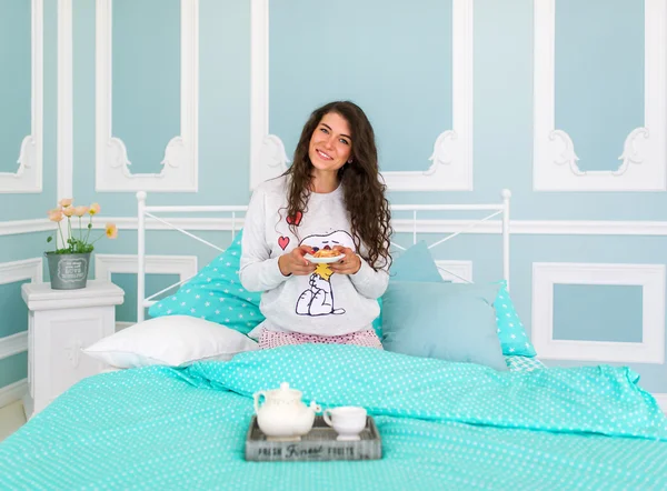 Молода красива жінка в ліжку з тортами — стокове фото