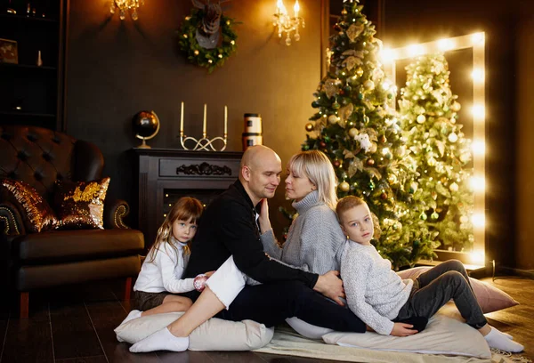 Happy family of four persons near decorated christmas tree. Celebration new years holidays