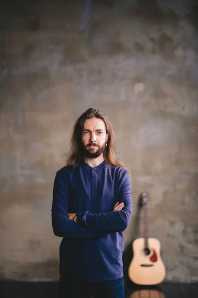 Stijlvolle Jonge Bebaarde Man Met Een Gitaar Poseren Terwijl Hij — Stockfoto