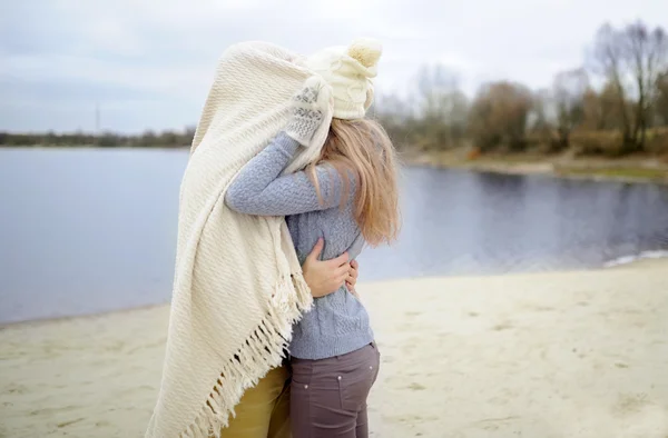 Killen och tjejen omfamna på en strand — Stockfoto