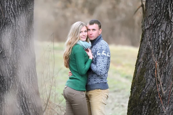 Le mec et la fille se tiennent entre les arbres — Photo