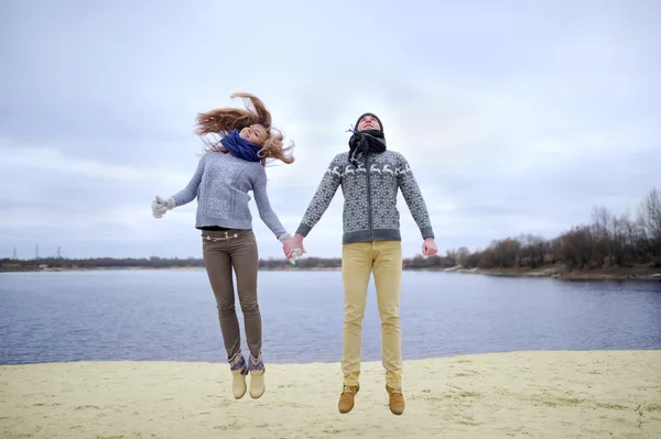 De jongen en het meisje lopen op een woestijn herfst strand — Stockfoto