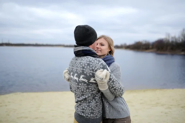 De jongen en het meisje lopen op een woestijn herfst strand — Stockfoto