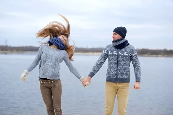 The guy and the girl walk on a desert autumn beach — Stock Photo, Image