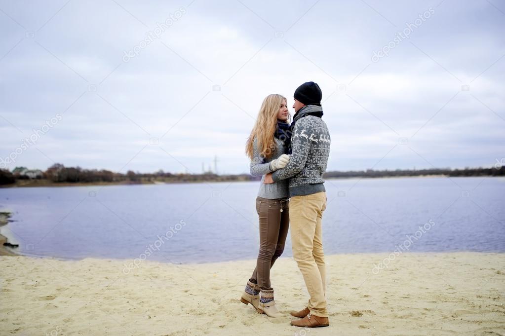 the guy and the girl walk on a desert autumn beach