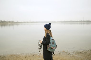 Mavi paltolu kız nehir boyunca yürür