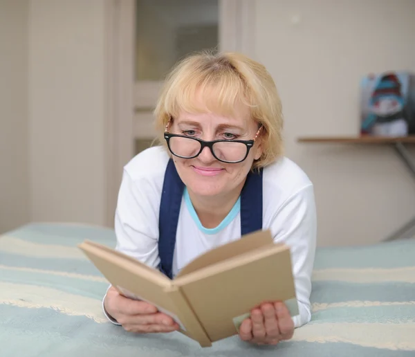 La mujer con gafas lee el libro — Foto de Stock