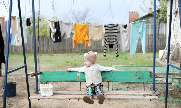 Дитина трясеться на гойдалці в селі — стокове фото