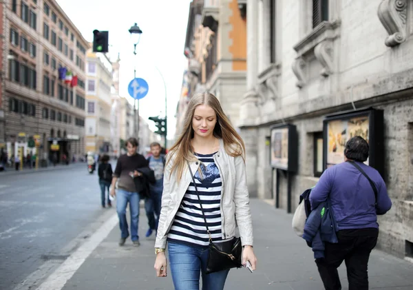 La jeune fille en jean va dans la rue de la ville — Photo