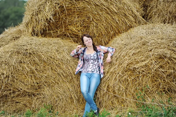 A menina em calça em um palheiro — Fotografia de Stock