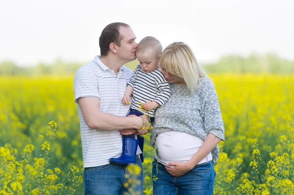 Famille de trois personnes sur un champ de viol — Photo