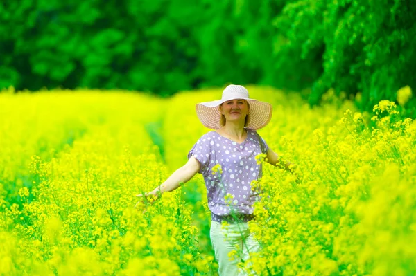 La mujer en un sombrero en un campo de violación — Foto de Stock