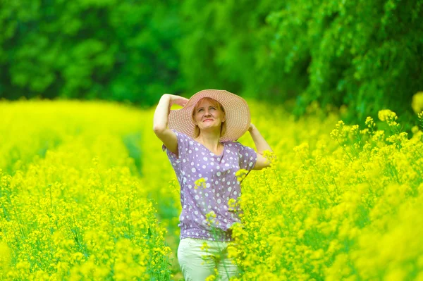 The  woman in a hat on a rape field — Stock Photo, Image