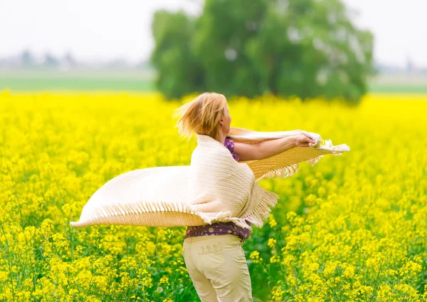 The beautiful woman dances on a rape field — Stock Photo, Image