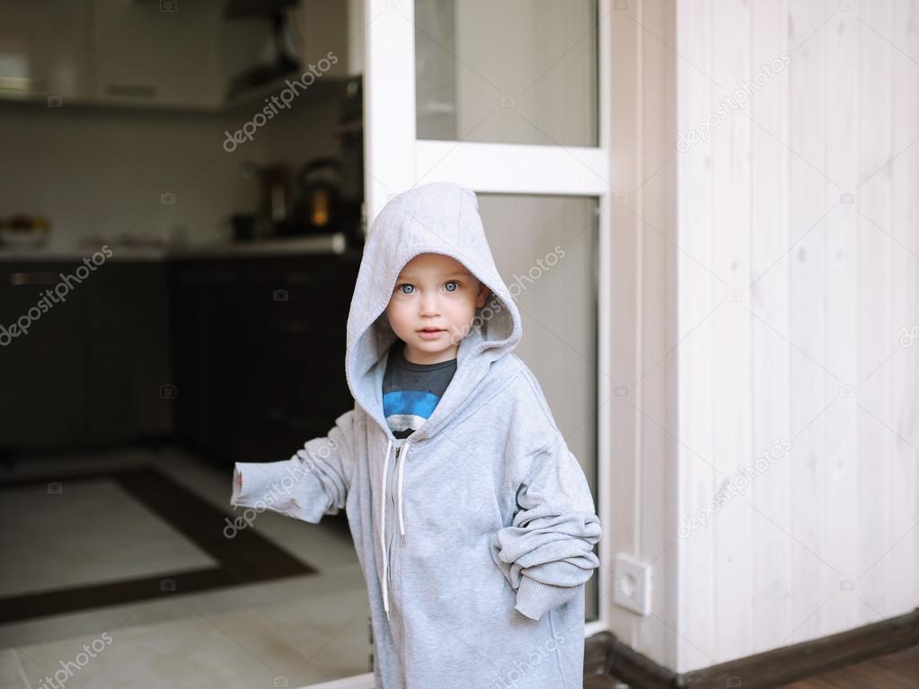 the kid poses in a jacket of the big size