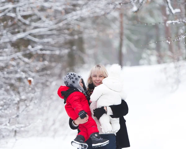 Mãe com filho e filha está no parque de inverno . — Fotografia de Stock