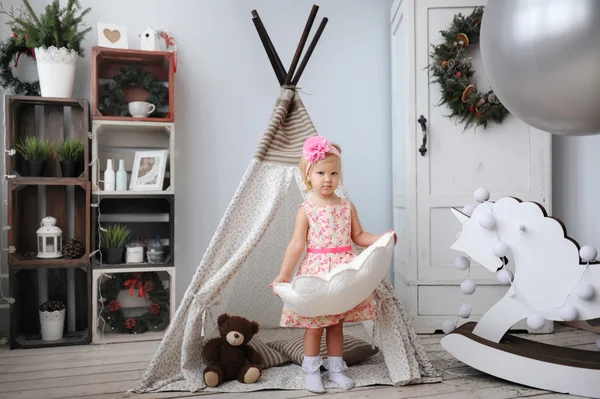 Das kleine Mädchen spielt im Kinderzimmer. — Stockfoto