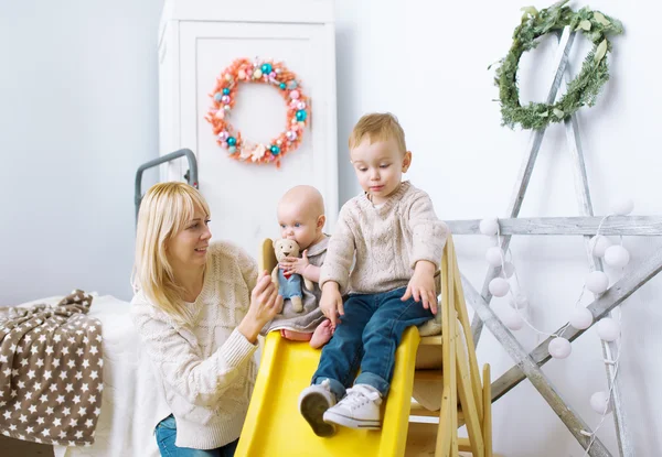 Mutter und Kinder spielen gemeinsam im Kinderzimmer. — Stockfoto