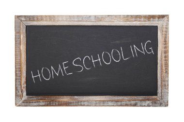 Tebeşirle yazılmış okul tahtası ve beyazlar içinde evde eğitim mesajı.