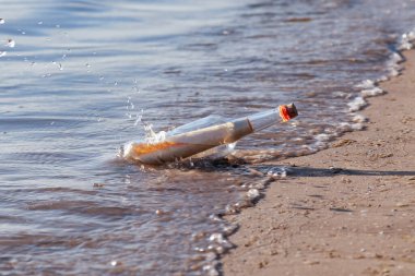 Plajda bir şişede mahsur kalmış bir mesaj.