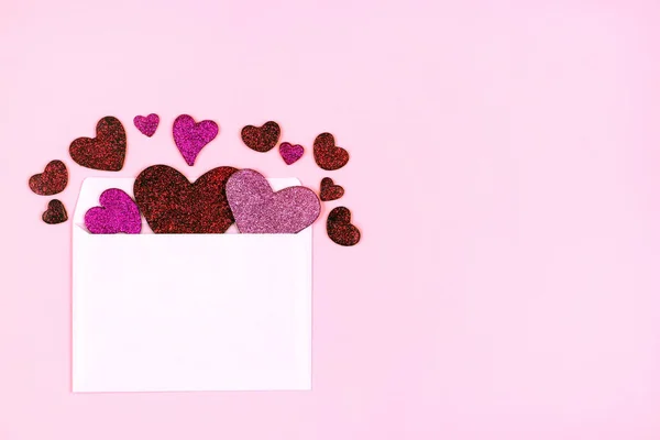 Envelope de papel branco com corações de Valentim glitter no fundo rosa. Conceito de carta de amor. Dia das Mulheres, Dia das Mães, Modelo do Dia dos Namorados. Vista superior com espaço de cópia — Fotografia de Stock