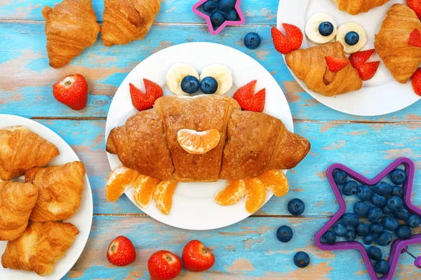 Idéia divertida para crianças café da manhã. Croissant de caranguejo bonito com bagas e frutas Fotografia De Stock