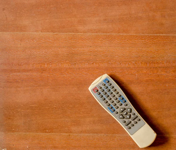 Старый пульт управления телевизором на деревянном полу — стоковое фото